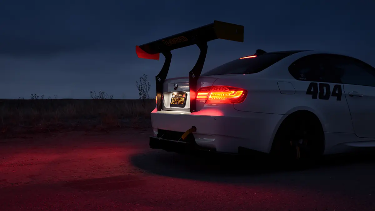White E92 BMW M3 track car at night on the Colorado plains