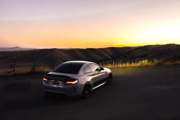 Rear three-quarter of the M2 Competition at sunset